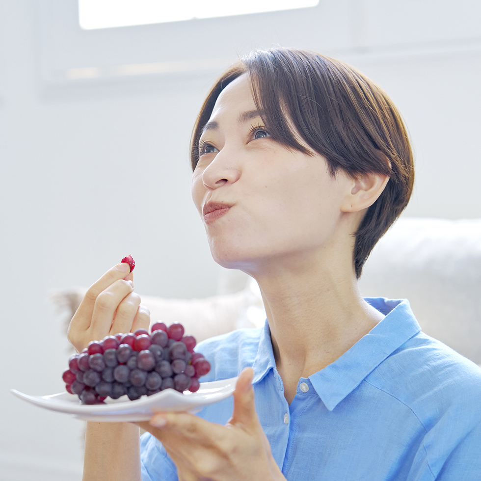 ブドウを食べる女性